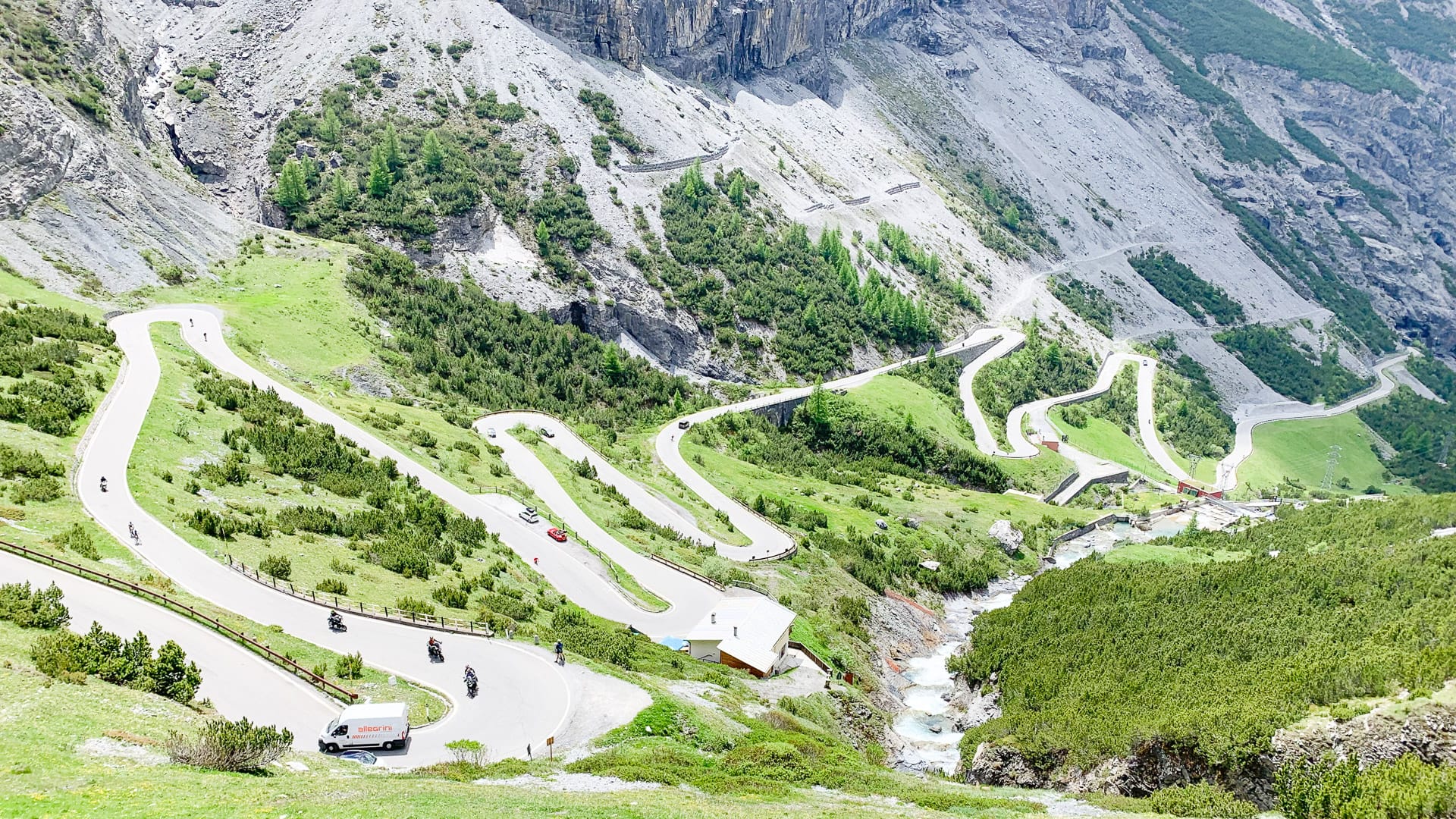 Cyclists riding downhill along part of the Stelvio Pass in the Italian Alps